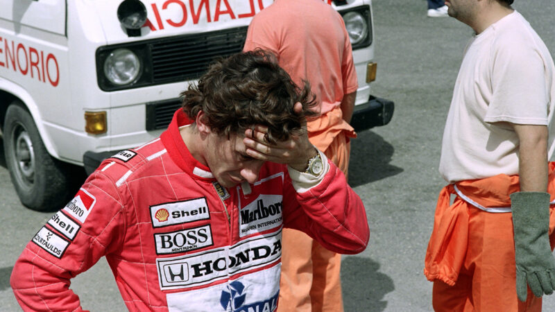 Ayrton Senna holds his head in his hands after seeing wrecked Lotus F1 car of Martin Donnelly at the 1990 Spanish Grand Prix weekend